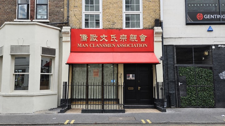 De gevel van de Man Clansmen Association in Londen: rood uithangbord met 僑歐文氏宗親會 en een rode luifel boven de deur